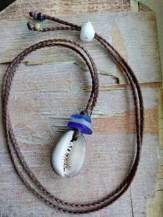 Handmade Blue Sea Glass Necklace Men Women Sinew Braid Hawaiian Cowrie Shell Blue Jewelry With Adjustable Cord For Beach, Blue Jewelry With Adjustable Cord For Vacation, Blue Adjustable Cord Jewelry For Vacation, Artisan Jewelry With Adjustable Cord For Beach, Unique Blue Jewelry For The Beach, Beach Jewelry Blue Hand-wrapped, Unique Beach Jewelry With Adjustable Cord, Blue Adjustable Cord Necklace For Beach, Bohemian Blue Jewelry With Adjustable Cord