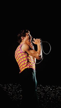 a man singing into a microphone in the dark