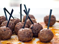 there are many meatballs on the plate with toothpicks sticking out of them