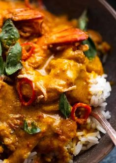 a close up of a plate of food with rice and meat on it, garnished with green leaves