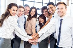 a group of business people holding hands in the middle of a circle with their arms around each other