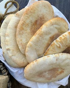 some bread is sitting on a plate next to a rope and burlap bag