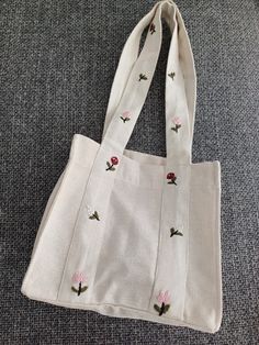 This unique handmade embroidered flower bag is a perfect accessory that combines natural charm with elegance. Made from high-quality and durable fabric, this bag features meticulously embroidered flower motifs that catch the eye. Features: Material: High-quality natural fabric Dimensions: Width: 28 cm, Height: 26 cm, Depth: 14 cm Embroidery: Handmade flower motifs Color: Cream/beige  Usage: Ideal for daily use, shopping, beach trips, or adding a touch of elegance to special occasions Carrying: W Flower Motifs, Beach Trips, Flower Bag, Natural Fabric, Handmade Flower, Cream Beige, Fabric Bags, Handmade Flowers, Natural Fabrics