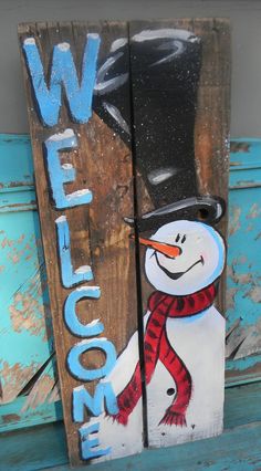 a wooden sign with a snowman painted on it