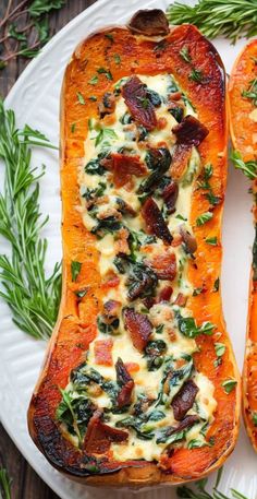 two stuffed sweet potatoes on a white plate with green sprigs next to them