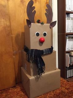 a cardboard box with a reindeer head and scarf on it, sitting in front of a bookshelf