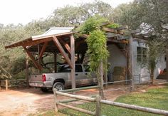 a truck is parked in front of a house with a covered porch and picnic area