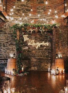 an indoor wedding venue with candles and greenery