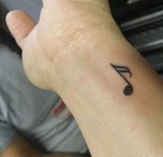 a small musical note tattoo on the wrist