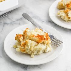 two white plates topped with food and a fork