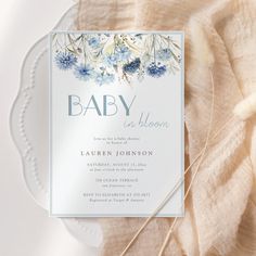 a baby in bloom card on top of a white plate with blue and yellow flowers