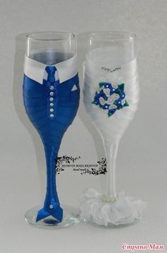 two wine glasses decorated with blue and white flowers, one in the shape of a bride's dress