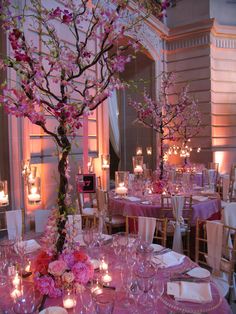 the tables are set with pink flowers and candles