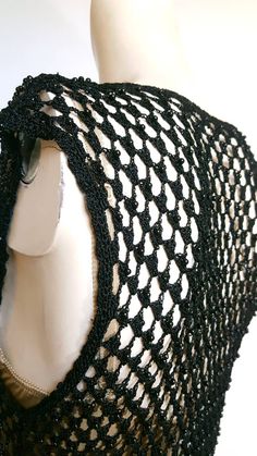 a crocheted black shawl on a mannequin's headpiece