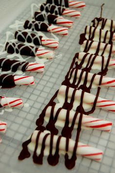 chocolate covered candy sticks are lined up on a baking sheet with white and red icing