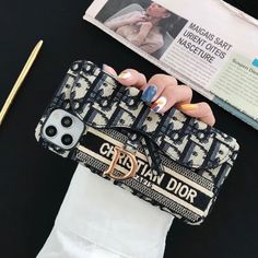 a woman's hand holding a black and white cell phone case with the words genta dior on it