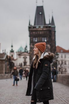 a woman standing in front of a castle