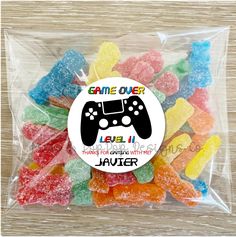 a bag filled with gummy bears sitting on top of a wooden table next to a game over sticker