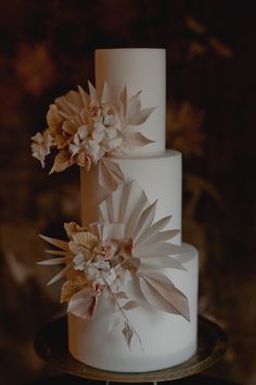 a three tiered white cake with flowers on top