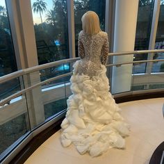 a woman in a wedding dress looking out the window