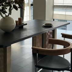 a table with two chairs and a vase on it