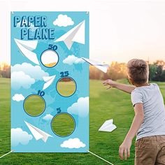 a young boy playing with a paper plane game