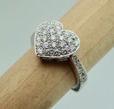 "This pave diamond heart shape ring is hand made in 18k white gold. There are 36 Pave set side diamonds totaling .76Cts, approximately 3/4 Carat The diamonds are VS clarity and G color range. We make all our own jewelry and focus on quality and durability. The ring is currently a size 6.25 you will be able to return it within the listed time frame for any reason at all. It will take 1-2 business days processing time. We can size it any size from 5 to 7 but it would be a FINAL SALE. It will take Diamond Heart Ring Hallmarked, Diamond Heart Cut Ring Hallmarked, Fine Jewelry Platinum Heart-shaped Rings, Fine Jewelry Platinum Heart Rings, Platinum Heart-shaped Fine Jewelry Rings, Fine Jewelry Heart-shaped Platinum Rings, Heart-shaped Hallmarked Diamond Ring, Wedding Heart Ring With Hallmarked Diamond, Valentine's Day Diamond Heart Ring, Hallmarked