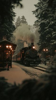 a train is coming down the tracks in the snow at night with its lights on