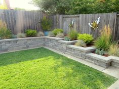 a backyard with grass, rocks and plants