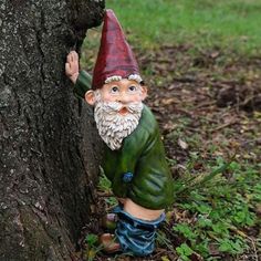 a gnome figurine is standing next to a tree