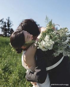 a man and woman embracing each other in the grass