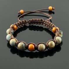 "Indulge in the earthy elegance of our woven braided bracelet.  Crafted using the intricate square knot technique, this bracelet showcases a harmonious blend of warm hues contained in the beige nylon satin cord, and ceramic and wood beads. Each knot and twist speaks of artisanal craftsmanship, making it a timeless addition to your collection, bringing style and balance to your everyday look. This braided bracelet is designed to be adjustable, ensuring a perfect fit for wrist sizes ranging from 7 Earthy Adjustable Bracelet With Sliding Knot, Brown Hand-strung Braided Bracelets With Round Beads, Brown Braided Bracelets With Hand-strung Round Beads, Brown Braided Bracelet With Hand-strung Round Beads, Friendship Brown Beaded Bracelets With Sliding Knot, Earthy Brown Braided Bracelets As Gift, Adjustable Brown Macrame Beaded Bracelets, Spiritual Brown Beaded Bracelets With Adjustable Cord, Adjustable Hand-strung Brown Braided Bracelets