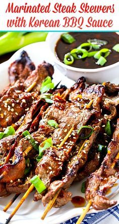 steak skewers with korean bbq sauce are on a white plate, ready to be eaten