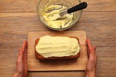 someone is spreading frosting on a loaf of bread