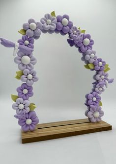 an arch made out of purple flowers and leaves