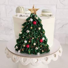 a decorated christmas tree cake sitting on top of a white plate