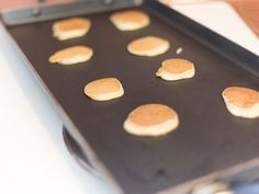 small pancakes are being prepared on a baking sheet for the oven to bake in