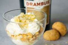 a glass filled with ice cream next to two cookies and a bottle of rumburst