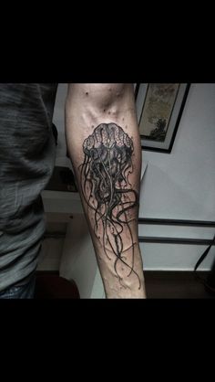 a man with a tattoo on his leg that has a jellyfish in the water