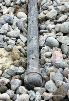 an old metal pipe laying on top of some rocks