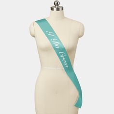 a white mannequin with a green ribbon on it