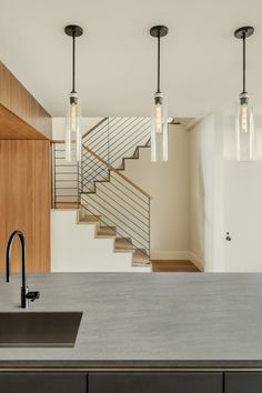 a kitchen with an island, sink and stairs