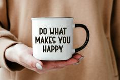 a woman holding a coffee mug that says do what makes you happy