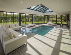 a living room filled with furniture and a swimming pool in the middle of an open floor plan