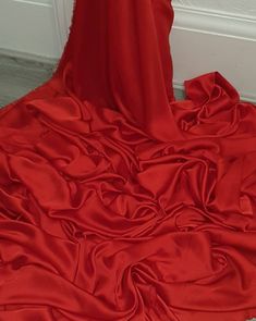 a red dress is laying on the floor