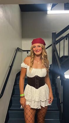 a woman in a pirate costume is standing on the stairs with her hands behind her back