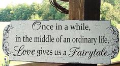 a wooden sign that says once in a while, in the middle of an ordinary life love gives us a fairy tale