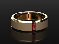 a gold wedding ring with a red stone in the center on a black background,