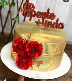 a golden cake with red roses on top and the words de repente hinda