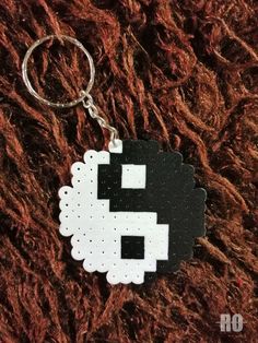 a black and white pixel keychain with an image of a sheep on it